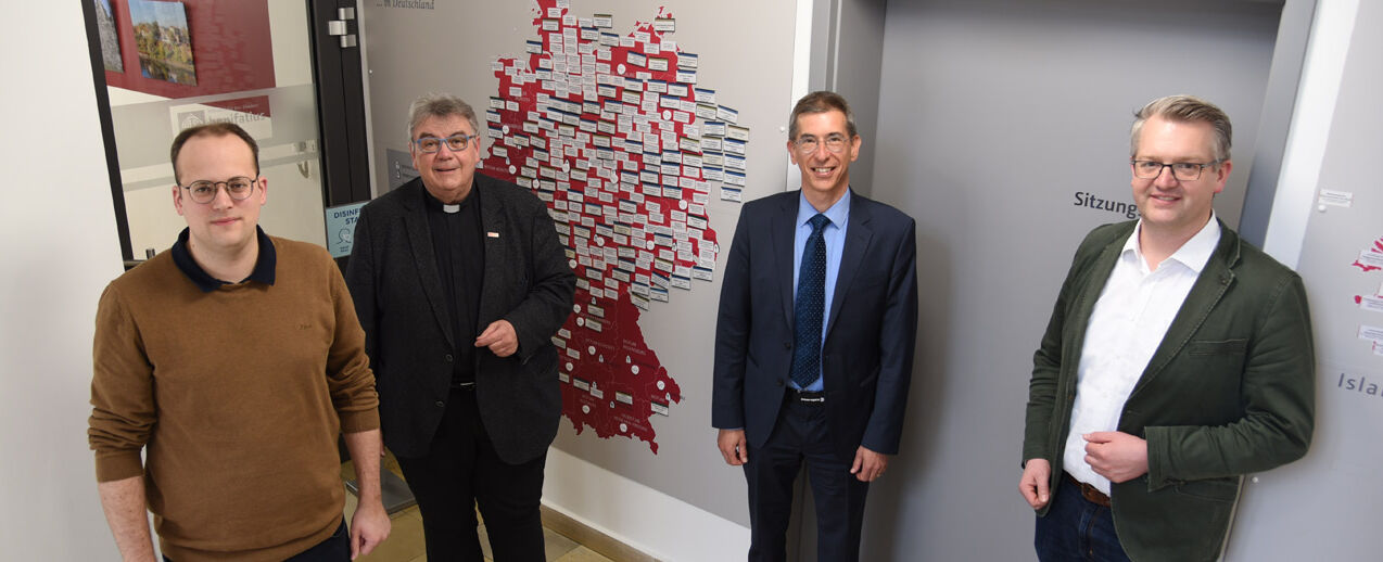 Im Bonifatiuswerk begrüßen Monsignore Georg Austen (Zweiter von links), Generalsekretär des Bonifatiuswerkes, Daniel Born (links) und Thomas Twents (rechts) den neuen Vorsitzenden des Diözesan-Bonifatuswerkes Köln, Nadim Ammann. (Foto: Simon Helmers)