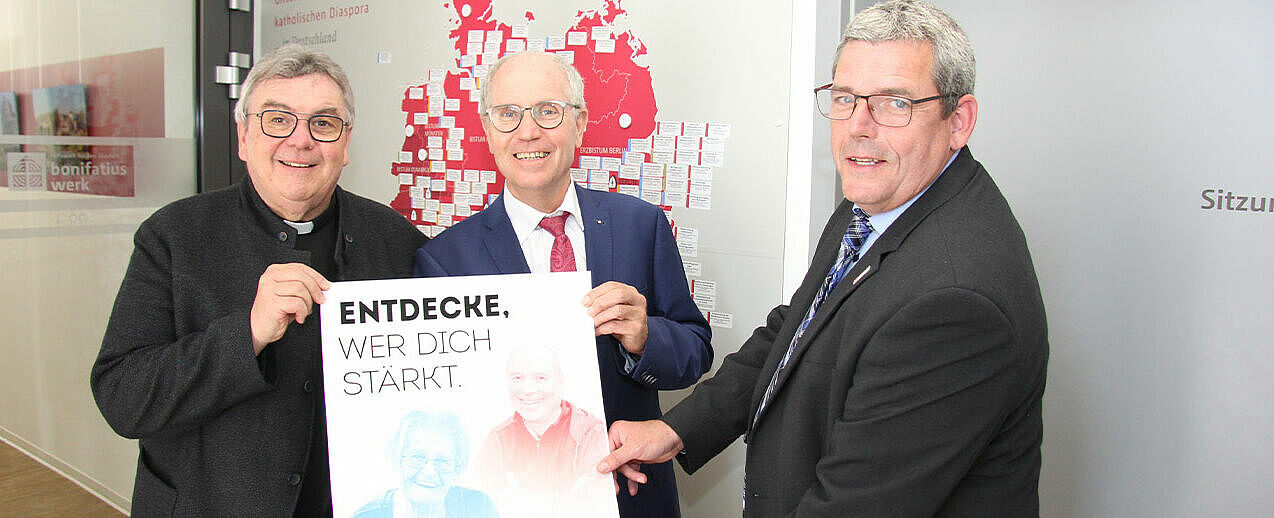 Bonifatiuswerk Generalsekretär Monsignore Georg Austen, Präsident Manfred Müller und Geschäftsführer Ingo Imenkämper (v.l.) präsentieren das neue Plakat zur Diaspora-Aktion 2023 mit dem Leitwort "Entdecke, wer dich stärkt.". (Foto: Matthias Band)
