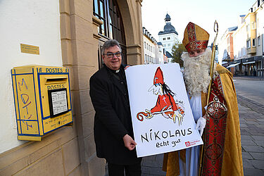Der Nikolaus und der Generalsekretär des Bonifatiuswerkes, Monsignore Georg Austen, präsentieren den gemalten Nikolaus von Udo Lindenberg.
