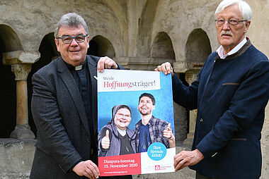 Msgr. Georg Austen und Präsident Heinz Paus präsentieren das neue Plakat zur Diaspora-Aktion 2020