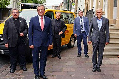 Bürgermeister Michael Dreier und CDU-Landratskandidat Christoph Rüther zum politischen Austausch im Bonifatiuswerk: Von Links: Monsignore Georg Austen (Generalsekretär Bonifatiuswerk), Bürgermeister Michael Dreier, Armin Kensbock (Pfarrer in Köthen), Ingo Imenkäper (Geschäftsführer Bonifatiuswerk), Bürgermeister Christoph Rüther und Heinz Paus (Präsident Bonifatiuswerk). Auf dem Bild ist ein BONI-Bus zu sehen, von denen das Bonifatiuswerk am heutigen Tag fünf weitere für die Gemeindearbeit in der Diaspora vergeben hat. Derzeit sind circa 600 solcher Fahrzeuge in Deutschland im Einsatz. Foto: Patrick Kleibold