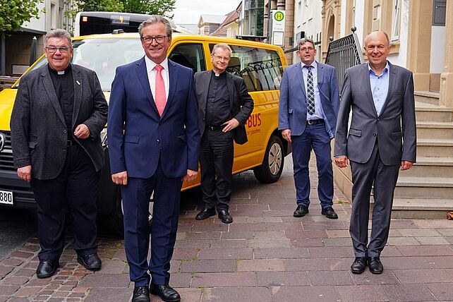 Bürgermeister Michael Dreier und CDU-Landratskandidat Christoph Rüther zum politischen Austausch im Bonifatiuswerk: Von Links: Monsignore Georg Austen (Generalsekretär Bonifatiuswerk), Bürgermeister Michael Dreier, Armin Kensbock (Pfarrer in Köthen), Ingo Imenkäper (Geschäftsführer Bonifatiuswerk), Bürgermeister Christoph Rüther und Heinz Paus (Präsident Bonifatiuswerk). Auf dem Bild ist ein BONI-Bus zu sehen, von denen das Bonifatiuswerk am heutigen Tag fünf weitere für die Gemeindearbeit in der Diaspora vergeben hat. Derzeit sind circa 600 solcher Fahrzeuge in Deutschland im Einsatz. Foto: Patrick Kleibold