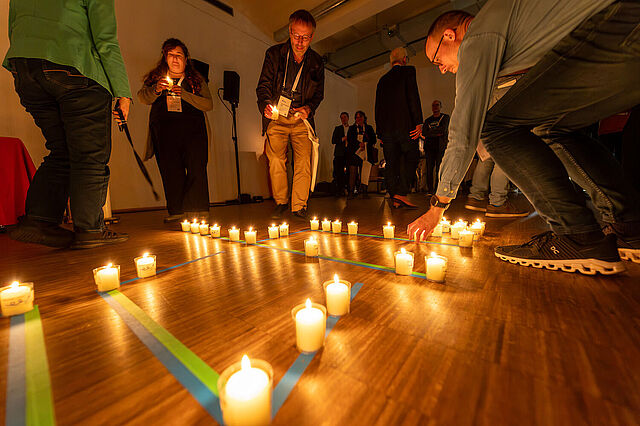 Beim Abend-Impuls, gestaltet vom Bonifatiuswerk, formten die Teilnehmenden spontan aus Kerzen den Begriff "dennoch". Foto: Hartmut Salzmann