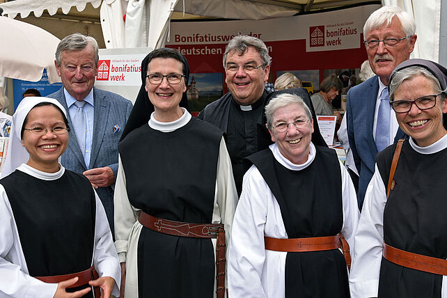 Traditionelle Andacht 1: Generalsekretär Monsignore Georg Austen (hintere Reihe Mitte), Ehrenpräsident Georg Freiherr von und zu Brenken (hintere Reihe Links)und Bonifatiuswerk-Präsident Heinz Paus begrüßen Schwester Brigitte Pinot, Schwester Anne Elizabeth Sweet, Schwester Agnes Pham und Schwester Sr. Hanne-Maria Berentzen am Informationsstand des Bonifatiuswerkes. Foto: Patrick Kleibold