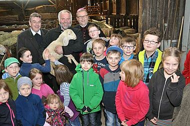 Der Osnabrücker Bischof Dr. Franz-Josef Bode (hinten rechts) und Monsignore Georg Austen, Generalsekretär des Bonifatiuswerkes (hinten links) haben gemeinsam mit Kommunionkindern aus Büren die Schäferei von Burkhard Schmücker (hinten Mitte) in Siddinghausen besucht.