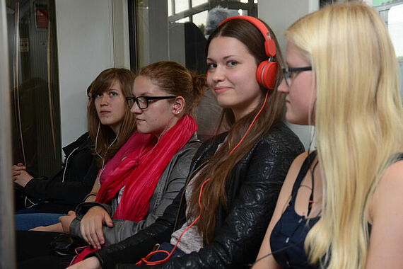 Mit Kopfhörern und m-p3-Player erleben Jugendliche ihren ersten S-Bahngottesdienst.