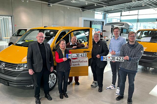 Monsignore Georg Austen (Vierter von links) übergibt den rapsgelben Bonibus an die Delegation aus Lübbecke (von links): Pfarrer Karl-Heinz Graute, Monika Geschke (Caritas), Günter Schmidt (Kirchenvorstand), Benedikt Getta (Außendienstmitarbeiter Gemeindeverband) und Florian Dreyer (Firmkatechet). Foto: Bonifatiuswerk/Marius Thöne