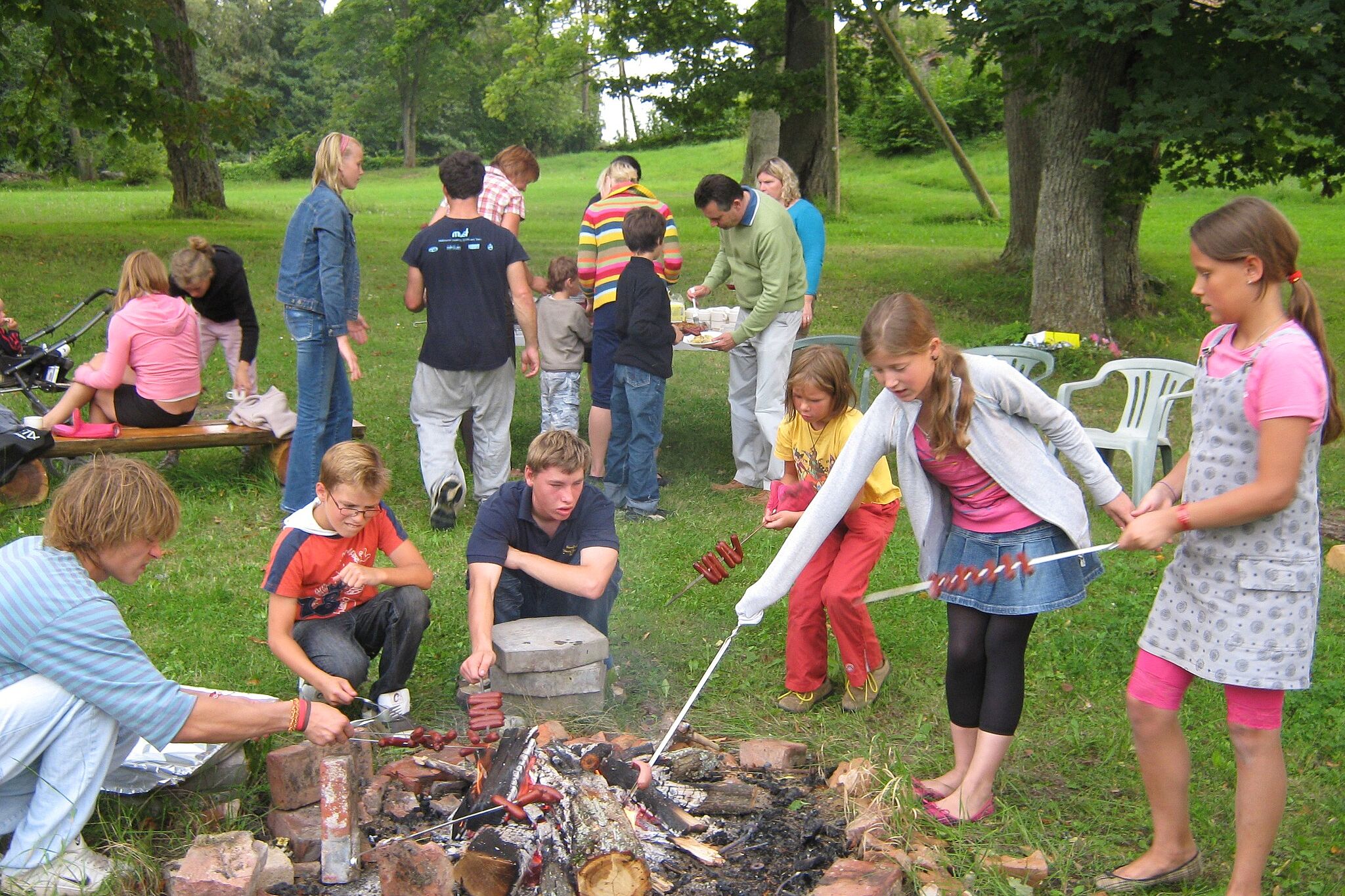 Kinder grillen Würstchen über dem Lagerfeuer. (Foto: Jean Amblard)