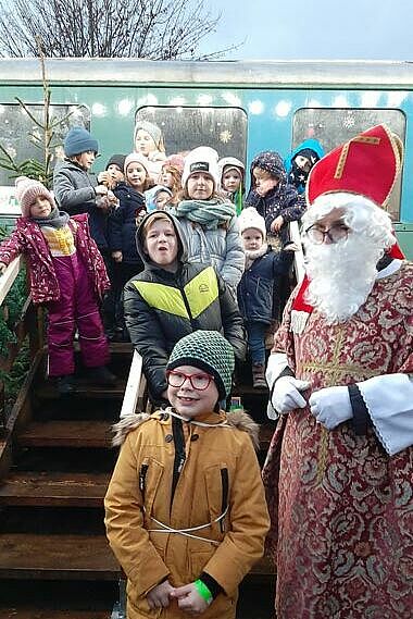 Der Nikolaus mit beschenkten Kindern vor dem "Vulkanexpress".