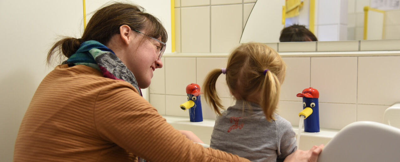 Mitarbeiterin Vera Glorius hilft beim Händewaschen im Kleinkindbereich. (Foto: S. Helmers)