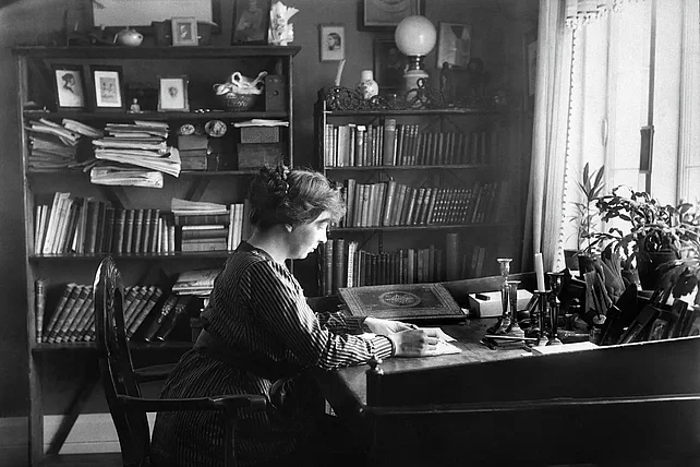 Sigrid Undset sitzt an ihrem Schreibtisch im Wohnzimmer. (Foto: Alvilde Torp, Bjerkebæk, Sigrid Undset's home)