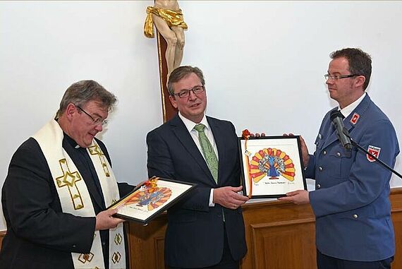 Der Bürgermeister von Paderborn, Michael Dreier, sprach ein kurzes Grußwort zur Haussegnung und überreichte Monignore Austen vom Bonifatiuswerk und Andreas Bierod von den Maltesern jeweils ein Bild vom Paderborner Künstler Hermann Reichold. Foto: Patrick Kleibold