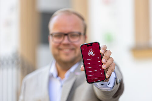 Julian Heese, Bereichsleiter "Missionarisch und diakonische Pastoral" im Bonifatiuswerk zeigt die Firm-App auf einem Handy. Foto: Hartmut Salzmann/Bonifatiuswerk