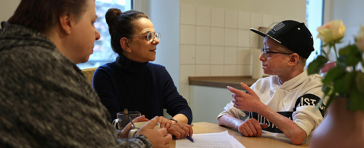 Luca Campos (r.) ist 19 Jahre alt. Aufgrund einer schweren Krankheit sitzt er im Rollstuhl. Zusammen mit seiner Mutter Heike (l.) nimmt er die Unterstützungsangebote von Beate Danlowski (Mitte), Leiterin des Kinderhospiz-Zentrums LEO, regelmäßig wahr. (Foto: Markus Nowak)