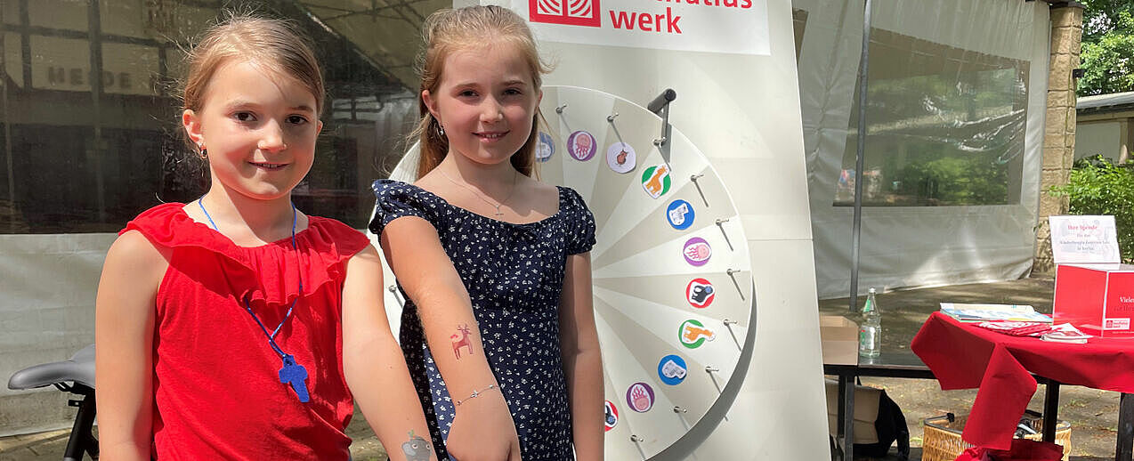Die Geschwister Melina-Jolie und Felija Michel sind am Bonifatiuswerk-Stand. Sie haben am Glücksrad gedreht und sich ein Tier-Tattoo auf ihren Arm machen lassen. Foto: Pia Wittek