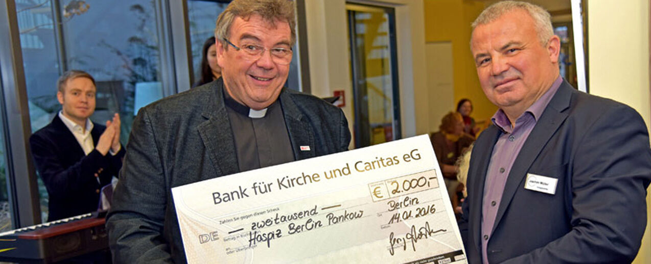 Monsignore Georg Austen (links) überreicht eine Spende der Georg Austen Stiftung Solidarität in Höhe von 2.000 Euro an den Leiter des Erwachsenenhospiz der Caritas in Berlin-Pankow, Joachim Müller. Foto: Kleibold