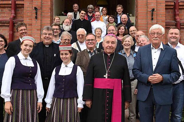 Gruppenfoto mit Bischof Pavlovskis und Studentinnen in lettischer Tracht. Foto. Sr. Theresita M. Müller
