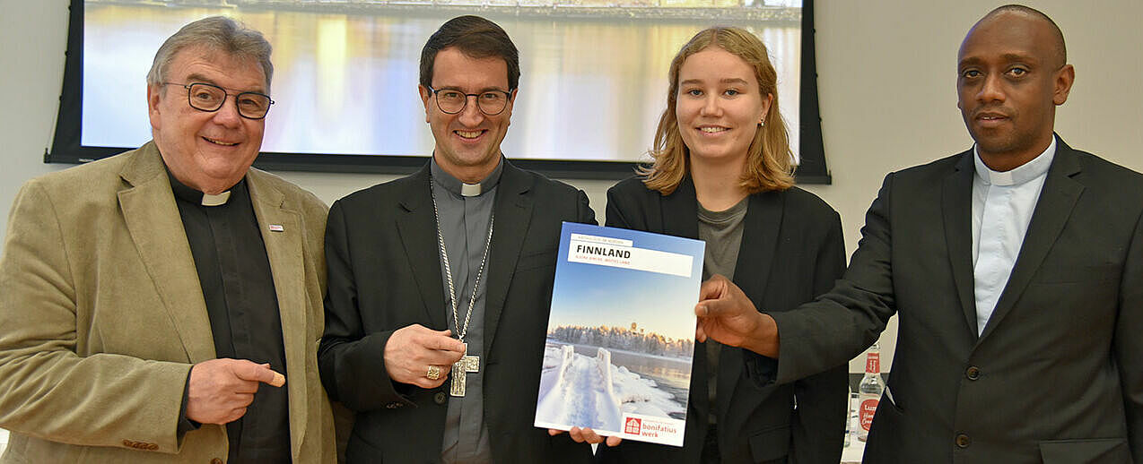 Bonifatiuswerk-Generalsekretär Monsignore Georg Austen (von links), Bischof Raimo Goyarrola (Bistum Helsinki), Bonifatiuswerk-Incomerin Antonia Tervaportti aus Finnland sowie Generalvikar Jean-Claude Kabeza (Bistum Helsinki) zeigen das neue Länderheft Finnland. Foto: Matthias Band/Bonifatiuswerk