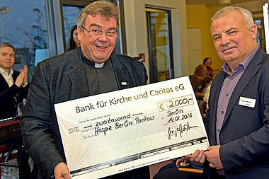 Monsignore Georg Austen (links) überreicht eine Spende der Georg Austen Stiftung Solidarität in Höhe von 2.000 Euro an den Leiter des Erwachsenenhospiz der Caritas in Berlin-Pankow, Joachim Müller. Foto: Kleibold