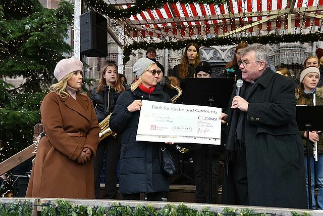 Petra Zöttlein, Leiterin des Caritas-Frauenhauses Hagar, nimmt einen Spendenscheck in Höhe von 5.000 Euro vom Bonifatiuswerk und von der Confiserie Riegelein aus Cadolzburg für die Arbeit in der Einrichtung entgegen. (Foto: Theresa Meier)