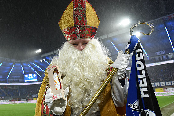Bischof Nikolaus erinnert daran, selbst Gutes zu tun. Mit Schokonikoläusen des Bonifatiuswerkes wird den Fans das Spiel versüßt. (Foto: Theresa Meier)