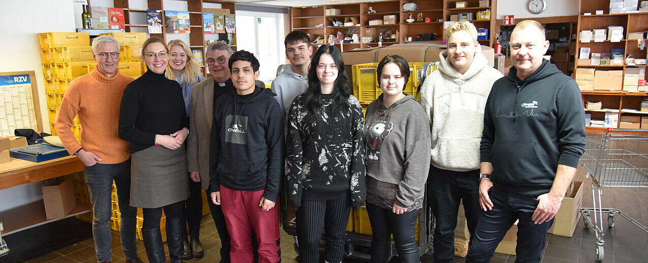 Fünf junge Menschen aus der Manege-Schule in Berlin-Marzahn schauen sich den Versand des Bonifatiuswerkes an. Es begleiten sie (von links) Dietmar Ahle vom Rotary-Club Paderborn Stadt+Land, Melanie Cramer, Präsidentin des Rotary-Clubs Paderborn Stadt+Land, Marisa Grummich, Referentin im Bonifatiuswerk, Monsignore Georg Austen, Generalsekretär des Bonifatiuswerkes und Robert Lisiecki, Lehrer an der Manege. (Foto: Pia Wittek)