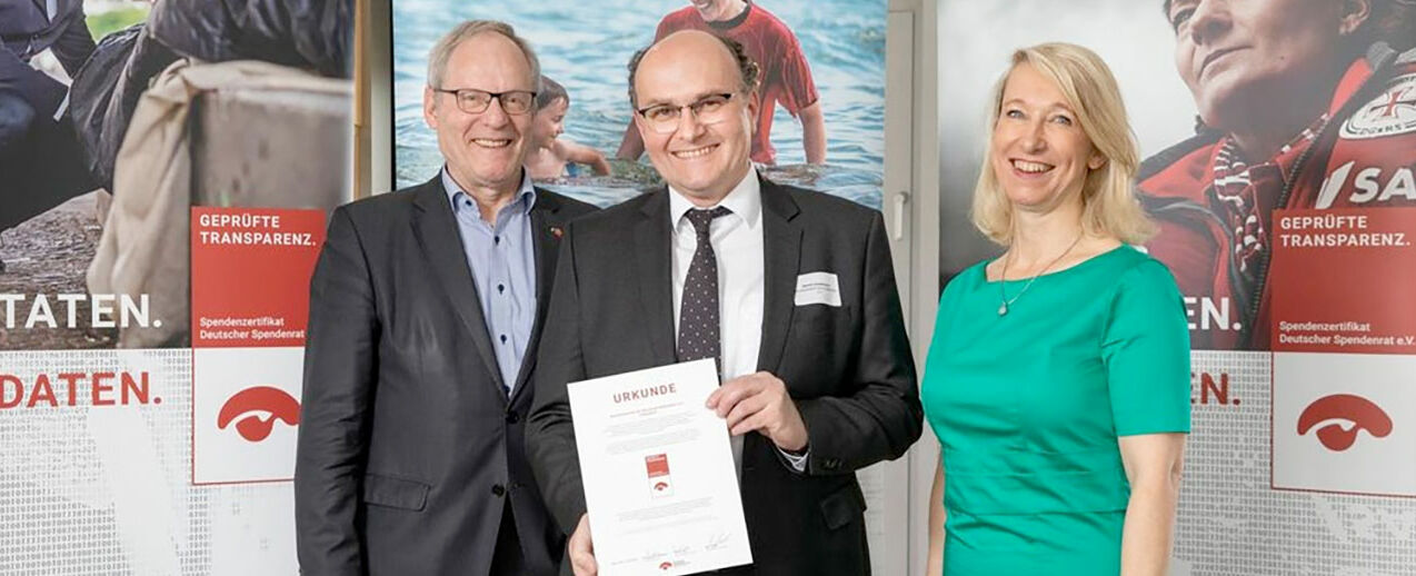 Daniela Geue (Geschäftsführerin Deutscher Spendenrat) und Wolfgang Stueckemann (Vorsitzender Deutscher Spendenrat) verleihen das Spendenzertifikat an Martin Guntermann vom Bonifatiuswerk © Joerg Sarbach