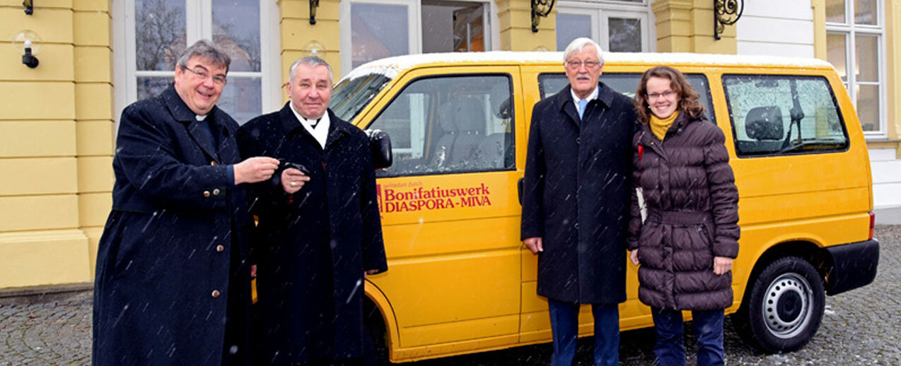 Monsignore Georg Austen überreicht den Schlüssel des BONI-Busses an Bischof Edvards Pavlovskis. Mit auf dem Foto: Der Präsident des Bonifatiuswerkes, Heinz Paus, und Inga Parsova, die den Bischof auf der Reise von Jelgava nach München und wieder zurück begleitet. Foto: Patrick Kleibold