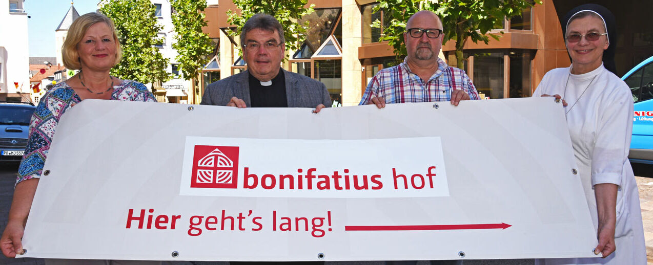 Den Bonifatiushof auf dem Parkplatz des Bonifatiuswerkes erreicht man über die Liboristrasse, eine der meist frequentierten Straßen zu Libori. Von Links: Karin Stieneke (Bereichsleiterin Kommunikation und Fundraising im Bonifatiuswerk), Monsignore Georg Austen (Generalsekretär Bonifatiuswerk), Ulrich Schulte (Almetalküche) und Schwester Theresita (Redakteurin im Bonifatiuswerk) laden ein zu einem Besuch auf dem Bonifatiushof. Foto: Patrick Kleibold 