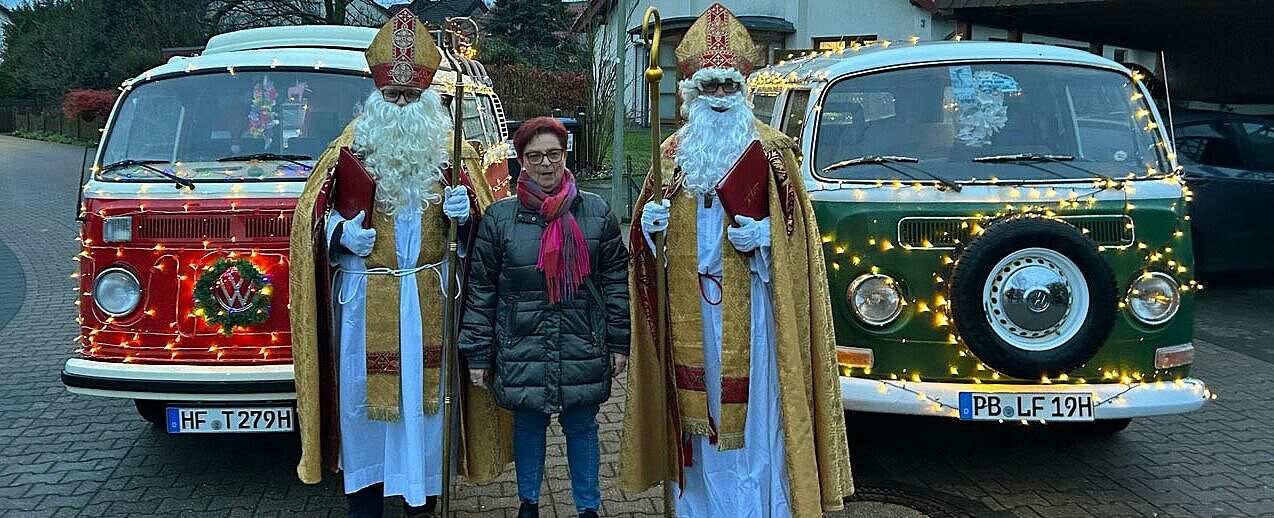 Die zwei Nikoläuse, hier mit XXX, kamen auf Einladung der Kolpingfamilie Paderborn-Marienloh mit den zwei festlich geschmückten Retro-VW-Bullis. (Foto: privat)