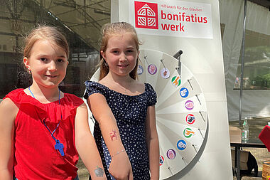 Die Geschwister Melina-Jolie und Felija Michel sind am Bonifatiuswerk-Stand. Sie haben am Glücksrad gedreht und sich ein Tier-Tattoo auf ihren Arm machen lassen. Foto: Pia Wittek