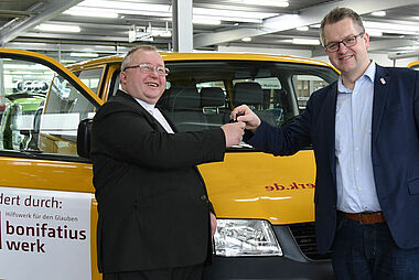 Thomas Twents (re) übergibt Pater Juris Krisuns aus Ventspils den Autoschlüssels des BONI-Busses. (Foto: Sr. Theresita M. Müller)