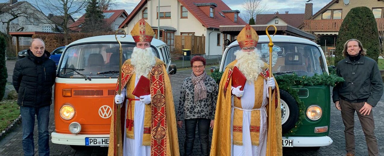 Florian Weskamp (re) und Klaus Hentze (li) mit ihren VW Bullis und Maria Halsband (mitte) mit den Nikolausdarstellern. (Foto: Maximilian Heese)