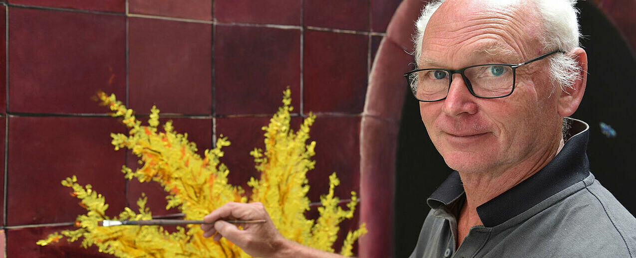 Künstler Thomas Jessen malt auf dem neuen Altarbild eine Forsythie. (Foto: Simon Helmers)