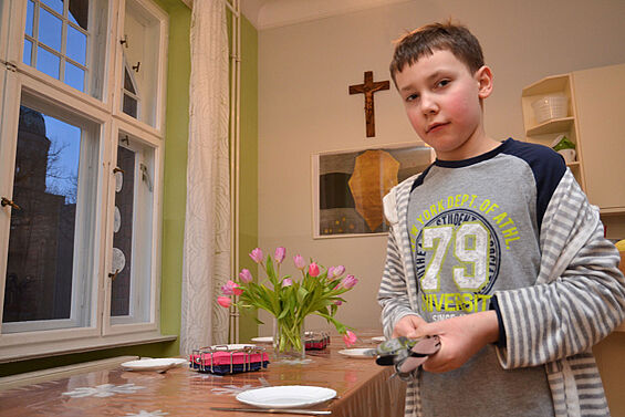 Dominik deckt den Tisch: der Dienst für die Gemeinschaft ist Teil des pädagogischen Konzepts. Foto: A. Herrmann