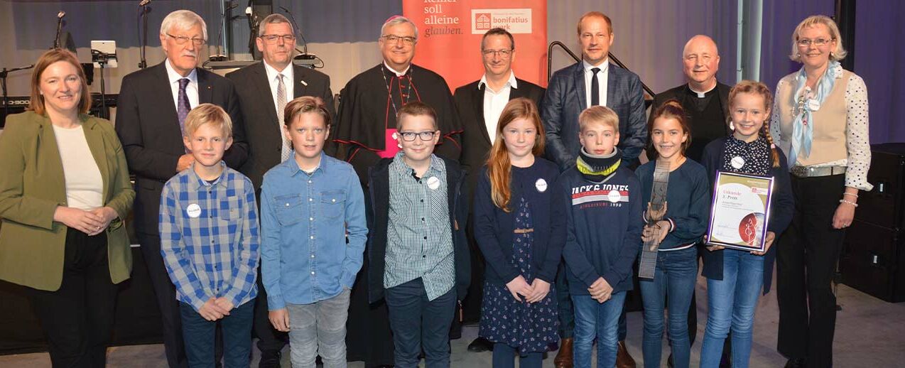 Der erste Platz des Bonifatiuspreises: KinderPilgerClubs Telgte, Künstlerin Petra-Maria Wewering (rechts) und Propst Dr. Michael Langenfeld (3.v.r.), gemeinsam mit ZDF Moderator Tim Niedernolte (5.v.r.), Bonifatiuswerk-Präsident Heinz Paus (2.v.l.) Bonifatiuswerk Geschäftsführer Ingo Imenkämper (3.v.l.), Bischof Dr. Wiesemann (Mitte hinten) und Katharina Binz Stellv. Ministerpräsidentin des Landes Rheinland-Pfalz (links) (Foto: Marius Thöne)