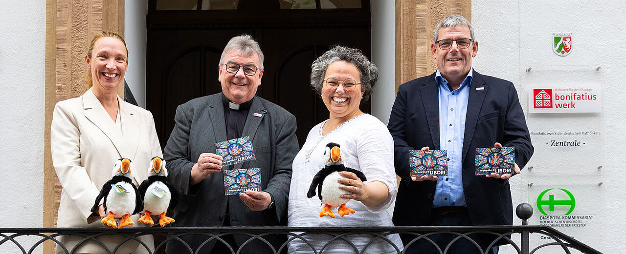 Katrin Füchtmann (Bereichsleiterin Fundraising), Bonifatiuswerk-Generalsekretär Monsignore Georg Austen, Christelle Lindhauer (Referentin Fundraising) und Bonifatiuswerk-Geschäftsführer Ingo Imenkämper (v.l.) zeigen die Papageientaucher „Aki“, das Maskottchen aus der Kinderzeitschrift „bonikids“ und die neue Klappkarte mit dem Libori-Tusch. Beides wird am Infostand des Bonifatiuswerkes verkauft. Foto: Hartmut Salzmann