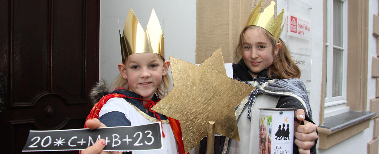 Charlotte (links, 8) und Zelda (11) aus der Pfarrei St. Liborius in Paderborn bringen den Segen "20 C + M + B + 23" ins Bonifatiushaus. (Foto: Matthias Band)