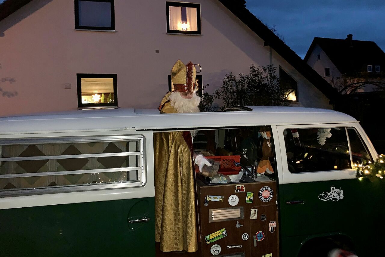 Der heilige Nikolaus verteilt aus dem VW-Bulli Stutenkerle an die Kinder. (Foto: Maximilian Heese)