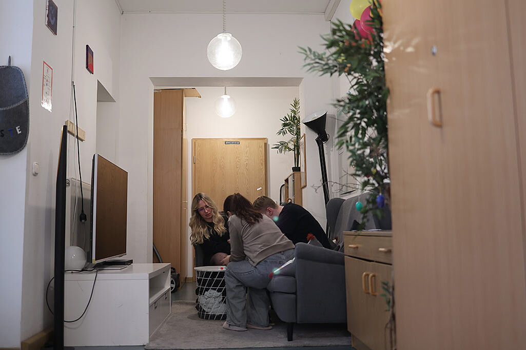 Eine Jugendgruppe verbringt Zeit in dem beengten Wohnzimmer, das eigentlich ein Flur ist. (Foto: Markus Nowak)