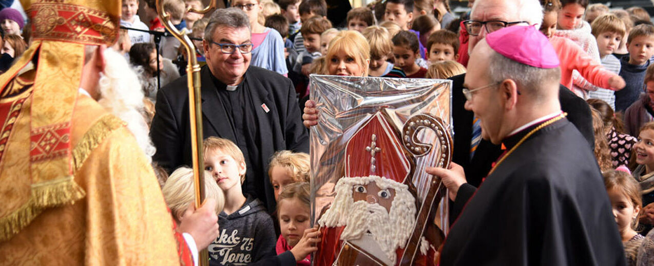 Bischof Nikolaus, Msgr. Georg Austen, Maite Kelly, Bürgermeister Norbert Plum und Bischof Dieser übergeben den Schülern den Printen-Nikolaus (v.l.) (Foto: Theresa Meier)