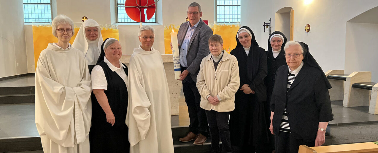 Die Augustiner Chorfrauen und ihre Gastschwestern beten für den Frieden. Ingo Imenkämper, Geschäftsführer des Bonifatiuswerkes (Mitte), übergibt eine Friedenskerze des internationalen Friedensgebetes #PeaceOnEarth. (Foto: Schwester Laetitia)