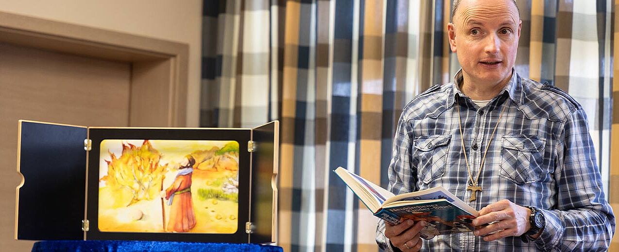 Fesselnd: Gemeindereferent Christof Stracke erzählt mit dem Kamishibai die Geschichte von Mose. (Foto: Hartmut Salzmann)