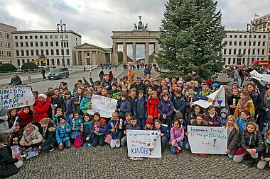 Gruppenfoto am Brandenburger Tor: Berliner Schulkinder mit Bischof Heiner Koch, Monsignore Georg Austen, Bischof Nikolaus, Maite Kelly und Eckhard Pols.