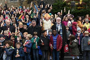 Die Schokonikoläuse kommen bei den Schülern der Domsingschule gut an. Gruppenbild mit Bischof Dieser, Maite Kelly, Msgr. Georg Austen, Bischof Nikolaus und Bürgermeister Plum (v.l.)