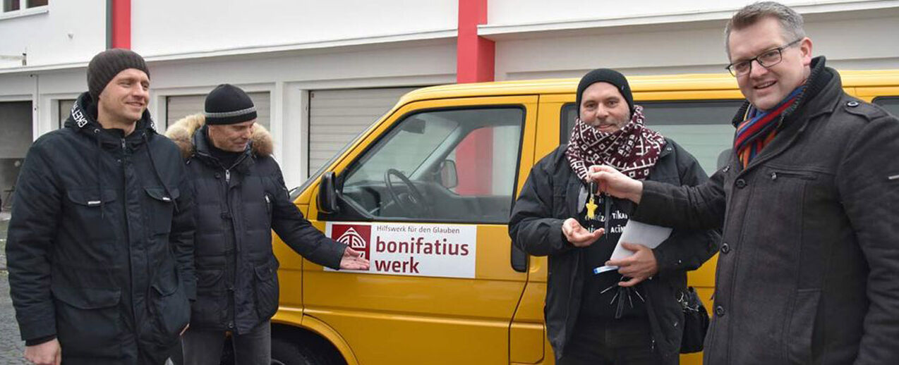 Thomas Twents (rechts) übergibt den Schlüssel des BONI-Busses an Pfarrer Pāvils Kamola (2. v. r.). Links die beiden Begleiter des Pfarrers. (Foto: Sr. Theresita M. Müller)