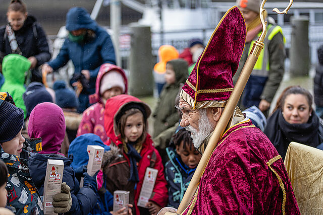 Die Kinder am Anleger in Bremen lauschen aufmerksam den Worten des heiligen Nikolaus. (Foto:Katholischer Gemeindeverband in Bremen/Christof Haverkamp)