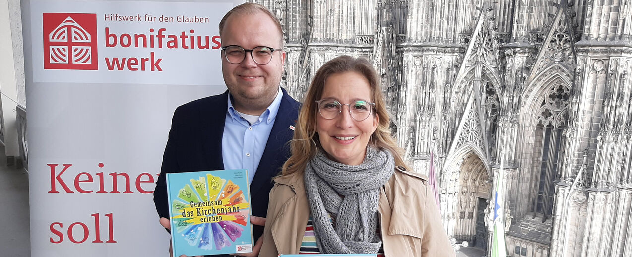 WDR-Moderatorin Yvonne Willicks und Julian Heese vom Bonifatiuswerk präsentieren das neue Kirchenjahrbuch vor dem Kölner Dom (Foto: Johannes Schröer)