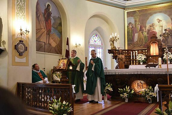 Monsignore Georg Austen predigt, ein lettischer Priester übersetzt. Foto: Sr. Theresita Müller