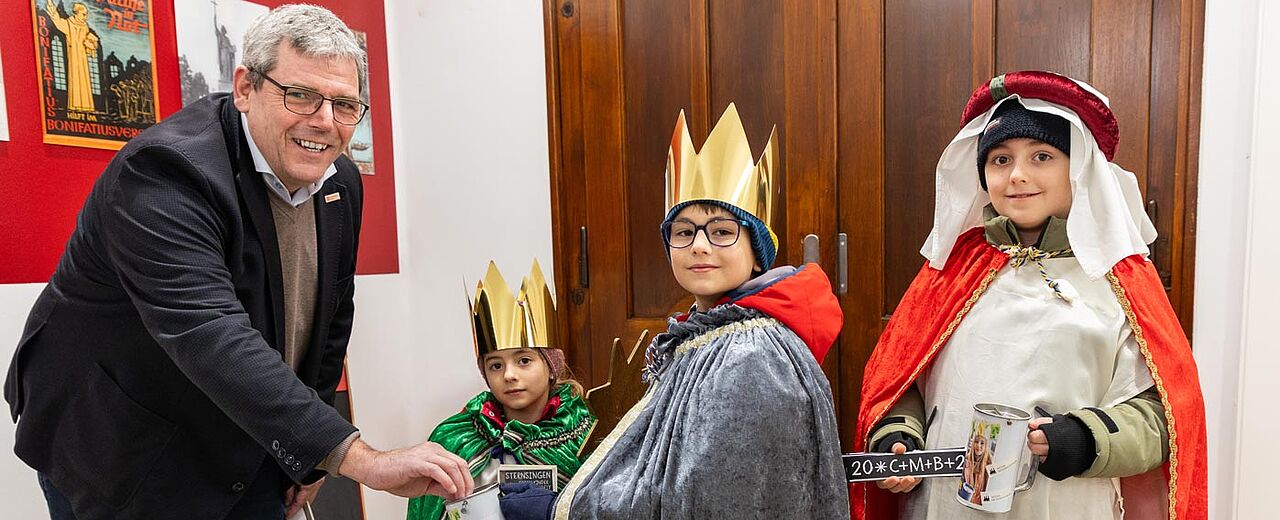 Bonifatiuswerk-Geschäftsführer Ingo Imenkämper begrüßte die Sternsinger Pauline (7), Justus (9) und Caspar (11) Hoppe (v.l.). Foto: Hartmut Salzmann
